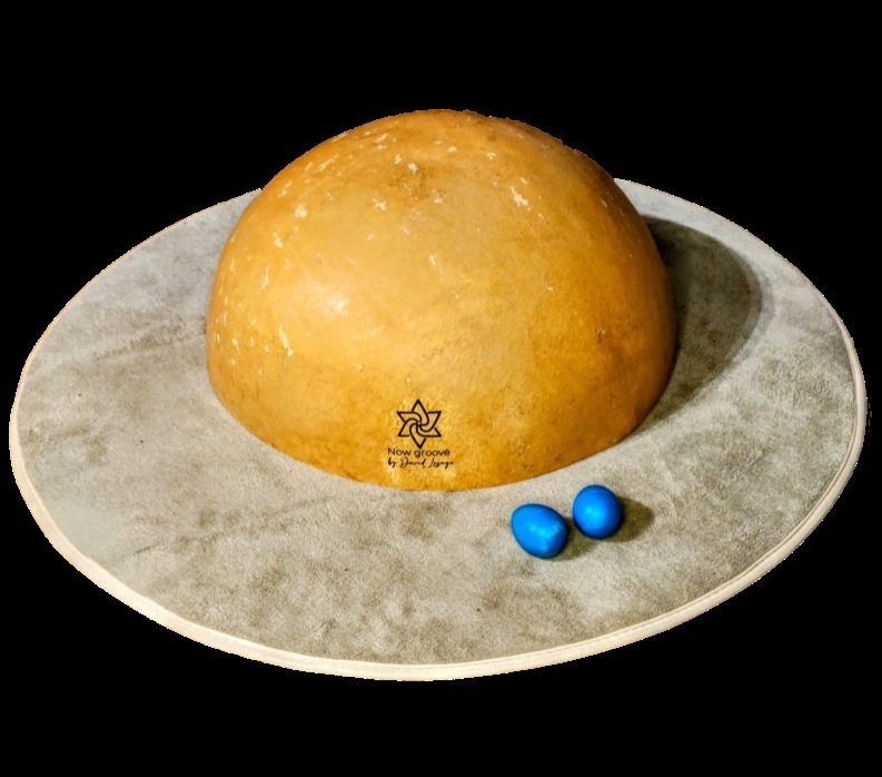 Une calebasse pyrogravee posee sur son tapis rond, avec les deux oeufs bleus