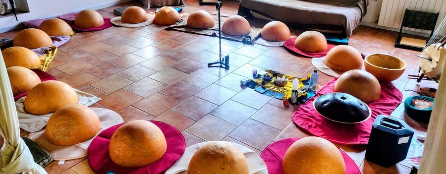 Une vingtaine de calebasses posees sur des tapis, disposees en cercle sur un sol carrele avant un atelier